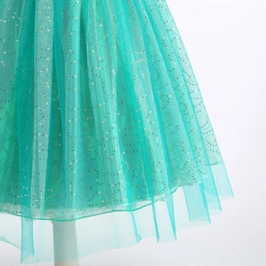 Détail d'une jupe en tulle turquoise avec paillettes dorées à motif vague de sirène