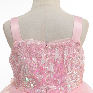 Detail of pink sequins, satin straps, and size tag on back of girl's party dress