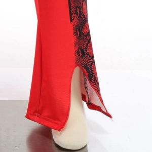 Detail of red flare pants with side python print and stylish split hem for costume