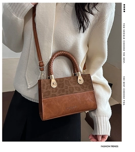 Detail view of a vintage leopard print and brown leather crossbody bag with woven handle
