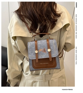 Detail of grey felt mini backpack with brown leather straps and cat illustration on cover