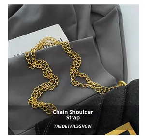 Close-up of a chunky gold chain strap on a vintage black quilted crossbody bag