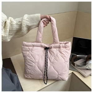 Detail of pink quilted tote bag with heart embroidery and drawstring closure