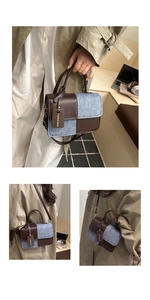 Detail of vintage contrast color handbag featuring brown leather and blue denim stitching