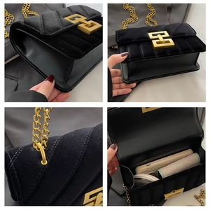 Detail of black velvet crossbody bag featuring golden chain and geometric metal clasp