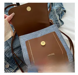 Detail of denim patchwork crossbody bag showing internal storage and magnetic snap button
