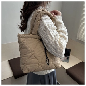 Close-up of quilted tote bag with heart stitching and padded shoulder strap detail