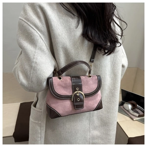 Detail of pink suede and brown leather crossbody bag with metallic buckle accent