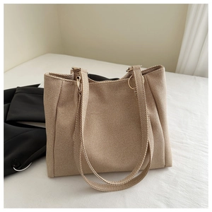 Close-up of beige twill canvas tote bag with textured fabric and metal ring detail