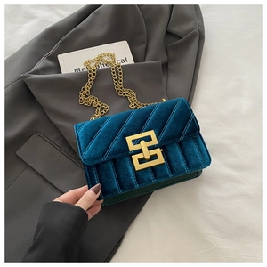 Close-up of sky blue velvet crossbody bag with luxury gold chain and metal lock detail