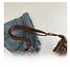 Détail de la bandoulière rembourrée réglable et texture matelassée du sac marron