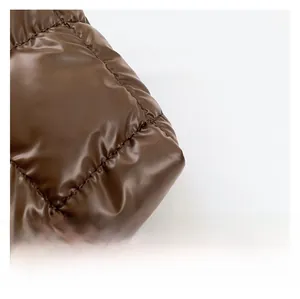 Gros plan du tissu matelassé marron foncé montrant la texture brillante et rembourrée