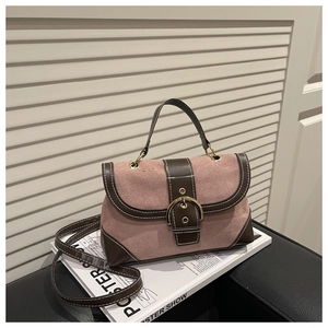 Detail of pink and brown contrast handbag with large gold buckle and contrast stitching