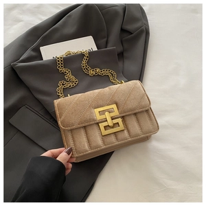 Macro shot of khaki quilted velvet handbag featuring luxury gold chain and clasp detail