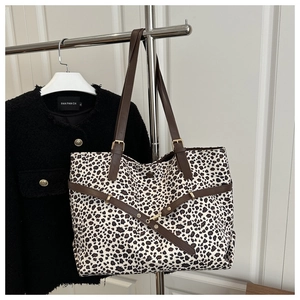 Détail du sac cabas léopard avec bandoulière en cuir marron et boucle en métal doré brillant