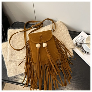 Détails d'un sac à bandoulière en daim marron avec perles en bois et longues franges