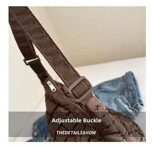 Détail de la boucle réglable et du tissu matelassé marron du sac à bandoulière chic