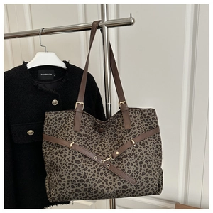 Détail du cabas imprimé léopard avec poignées en cuir marron et boucle dorée élégante