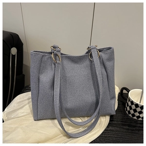 Detailed macro view of gray diagonal twill tote bag fabric with bronze metal rings