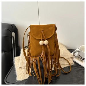 Détail d'un sac bandoulière en daim bohème avec de longues franges et des perles en bois
