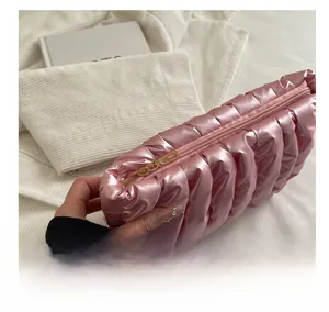 Detailed close-up of a pink quilted cloud bag featuring a smooth gold zipper closure