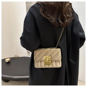 Detail of light khaki quilted velvet bag with gold square lock and fine chain strap