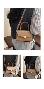 Detail view of khaki leather shoulder bag with gold metal lock and adjustable strap