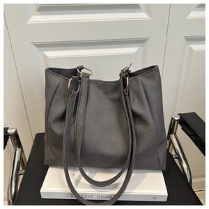 Detail of dark grey canvas tote bag with golden metal rings and sturdy shoulder straps