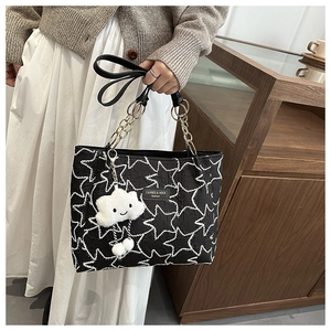 Détail du sac cabas à motif étoilé avec chaîne dorée et pendentif nuage en peluche