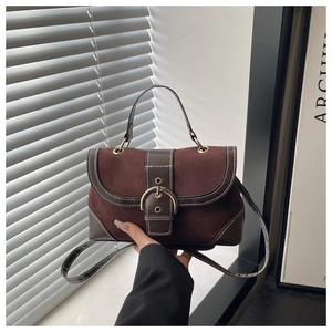 Detail of vintage suede handbag showing contrast stitching and gold metal buckle