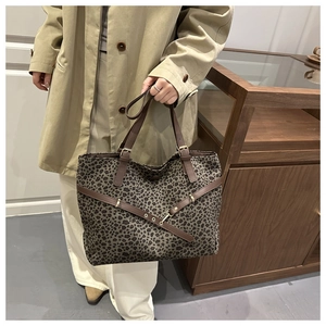 Détails du sac cabas léopard avec anses en cuir marron et accents métalliques dorés