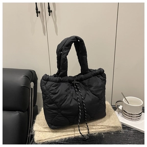 Detail showing heart quilted pattern and striped drawstring on black tote bag