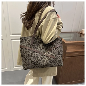 Vue détaillée du sac cabas imprimé léopard avec bandoulières en cuir et boucles en métal