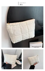 Détail de pochette en nylon matelassé blanc crème avec fermeture éclair dorée chic