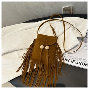 Détail du sac bandoulière en suédine marron avec glands décoratifs et perles en bois