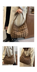 Gros plan d'un sac cabas matelassé marron foncé montrant la texture douce du nylon puffy