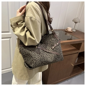 Détail du grand sac cabas à imprimé léopard avec des anses en cuir marron et boucles
