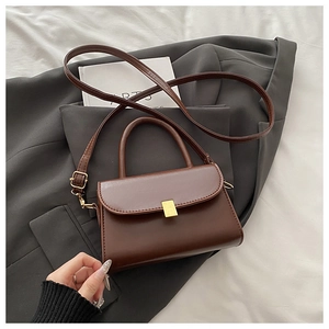 Detailed view of brown vintage PU leather handbag with square gold buckle and strap