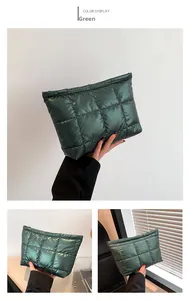 Détail du sac à main matelassé vert avec surpiqûres carrées et fermeture éclair métal