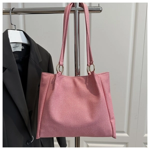 Pink fabric tote bag detail showing canvas texture and golden metal ring handle attachment