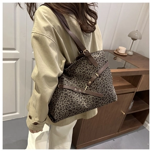 Grand sac cabas léopard avec bordure en cuir marron porté à l'épaule dans un intérieur