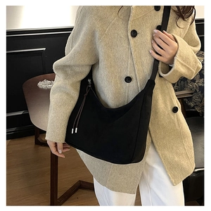 Dettaglio della borsa hobo in pelle scamosciata nera con lacci in pelle su modella