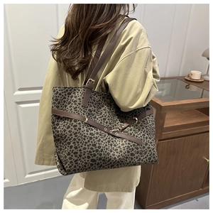 Détail d'un grand sac cabas léopard avec anses en cuir marron porté par un mannequin