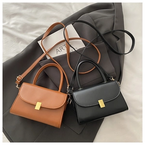 Detail of vintage crossbody bags with elegant gold square metal clasps and leather handles