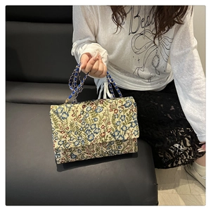 Nahaufnahme der floralen Stickerei und Leder-Kettengurt an einer Vintage-Handtasche
