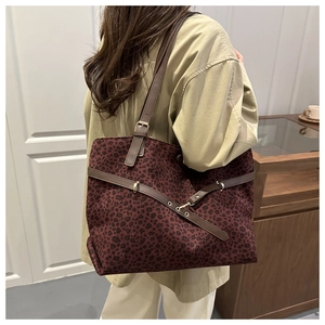 Détail du sac cabas léopard rouge foncé avec bandoulières en cuir et boucles métalliques