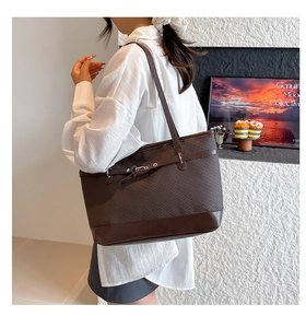 Detailed side view of brown textured tote bag worn by a model in a minimalist setting