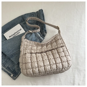 Détail du sac cabas matelassé beige avec poche zippée avant et bandoulière réglable