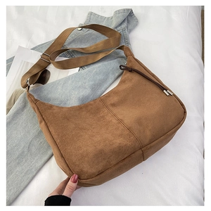 Borsa hobo in camoscio marrone con tracolla larga e coulisse su sfondo in maglia bianca