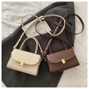 Detail of vintage square crossbody bags in beige and brown with gold metal buckles